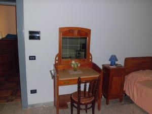 um quarto com uma secretária com um espelho e uma cama em B&B Cavour em Torre Maggiore