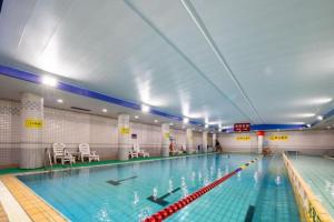 une grande piscine intérieure avec une piscine dans l'établissement Zhangjiagang Guomao Hotel, à Zhangjiagang