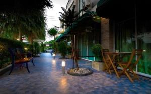a patio with chairs and a table and a tree at The Loom Rangsit in Pathum Thani