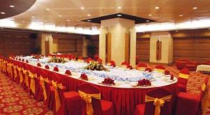 une longue table dans une salle de banquet avec des chaises rouges dans l'établissement Zhuhai Dehan Hotel, à Zhuhai 257 autres photos