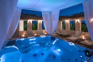 a large swimming pool with a blue canopy at Omiros Boutique Hotel (Adults Only) in Rethymno Town