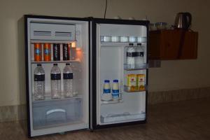 an open refrigerator with drinks and bottles of water at Water Paradise Resort in Cox's Bazar