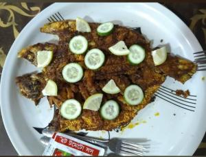 a plate of fish with slices of cucumbers on it at Water Paradise Resort in Cox's Bazar