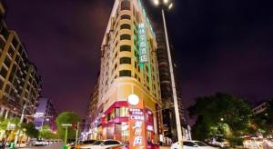 a tall building on a city street at night at GreenTree Inn Jieyang North Linjiang Road Express Hotel in Jieyang
