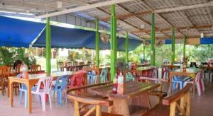 eine Gruppe von Tischen und Stühlen in einem Restaurant in der Unterkunft Kwanjai Resort in Chanthaburi