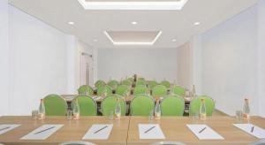 a conference room with green chairs and a table at IXO Bekasi in Bekasi
