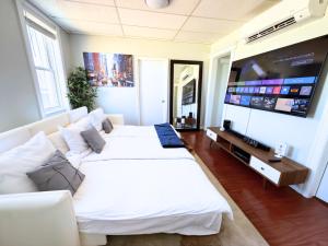 a living room with two beds and a flat screen tv at 3 Bedroom Smart Apartment Sleeps 11 with Parking Near Times Square in West New York +28 photos