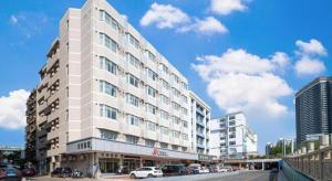 a large white building on a city street with cars at Jinjiang Inn Huizhou Xihu Lake Shuidong Street River View in Huizhou