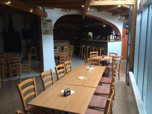 una gran mesa de madera y sillas en un restaurante en Hostel Klub malých pivovarů, en České Budějovice