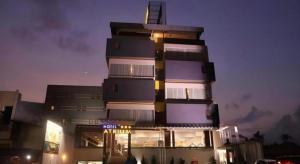 a tall building with a sign in front of it at Atrium Premiere Cilacap in Cilacap