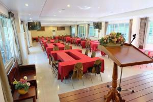 Habitación grande con mesas y sillas rojas. en Phu View Resort Khao Yai, en Mu Si