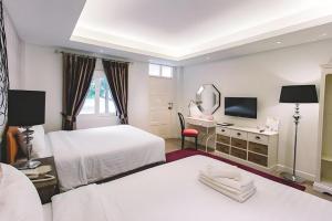 a hotel room with two beds and a mirror at Verona Boutique Hotel - The Verona Co., Ltd in Si Maha Phot +240 photos