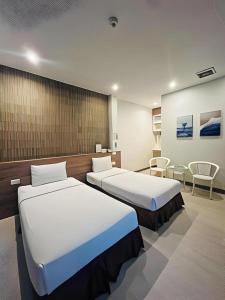 una camera d'albergo con due letti in una stanza di Seree Grand Resort a Hat Yai Altre 232 foto