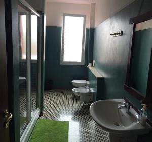 a bathroom with two toilets and a sink and a window at New Life in Mestre