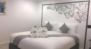 Un dormitorio con una cama blanca con almohadas blancas. en white house, en Phang Nga