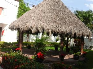 una gran cabaña de paja con flores en un patio en Exhaciendas Puerto Vallarta, en Puerto Vallarta