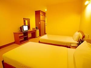 a hotel room with two beds and a television at Phuthong Place in Phayao