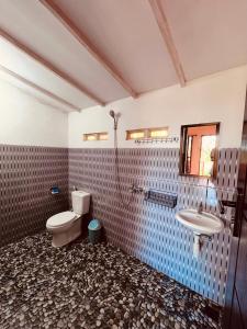 a bathroom with a toilet and a sink at Haris Homestay & Cottages in Senaru