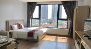 ein Hotelzimmer mit einem Bett und einem großen Fenster in der Unterkunft Phoenix Hotel 3 in Bắc Ninh