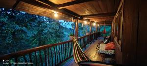 a porch with a hammock on a wooden balcony at Cabaña los Juanes, Jardin Antioquia in Jardin