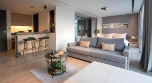 a living room with a couch and a kitchen at Neca Reiche in Hat Yai
