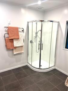 a glass shower in a bathroom with towels at St Okes Apartment- Peaceful retreat set in native bush Stay 1 night, 1 week or 1 month in Lower Hutt