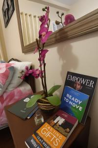 a table with two books and a flower on it at La Verti Residences Unit 1420 I Skyline Views & Luxe Stay Near MOA in Manila +9 photos