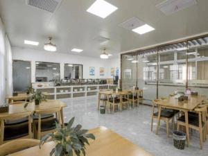 un ristorante con tavoli e sedie e una caffetteria di GreenTree Inn Zhangjiagang Yangshe Old Street Stadium a Zhangjiagang