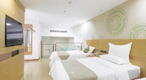 una camera da letto con due letti e una TV a schermo piatto di GreenTree Inn Zhangjiagang Yangshe Old Street Stadium a Zhangjiagang Altre 193 foto