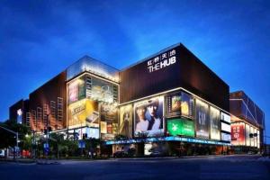 上海市にあるGreenTree Inn Shanghai National Convention and Exhibition Center Huaxiang Roadの夜にたくさんの看板が掲げられた大きな建物