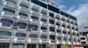a white building with balconies on the side of it at Grand PL Hotel in Phatthalung