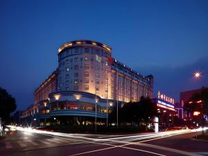 a building on a city street at night at New Century Hotel Taizhou 