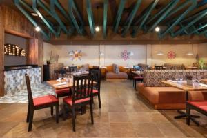 a restaurant with tables and chairs and a couch at Celuisma Playa Dorada All Inclusive in San Felipe de Puerto Plata