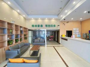 a living room with couches and a table in a room at GreenTree Inn Taizhou New District Hospital of Renmin Hospital Mingliu Express Hotel in Jiuligou