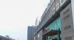 a building with a sign on the top of it at GreenTree Inn Taizhou New District Hospital of Renmin Hospital Mingliu Express Hotel in Jiuligou