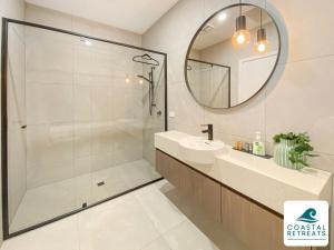a bathroom with a shower and a sink and a mirror at Rilley Retreat Inverloch, Luxe Townhouse Near Beach in Inverloch +27 photos