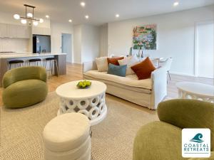 a living room with a couch and chairs and a kitchen at Rilley Retreat Inverloch, Luxe Townhouse Near Beach in Inverloch