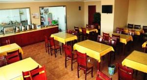 a restaurant with tables and chairs and a counter at GreenTree Alliance Zhejiang Zhoushan Putuoshan Zhujiajian Scenic Spot Hotel in Zhoushan