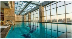 万寧市にあるWanning Yingbin Hotelの大きな窓付きの大きな屋内スイミングプール