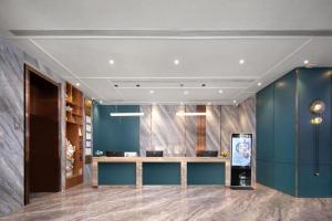 a lobby with blue walls and a counter in a room at Landmark Hotel in Zhuhai