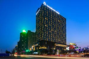 a tall building with lights on it at night at The QUBE Hotel Jingzhou in Caoshi