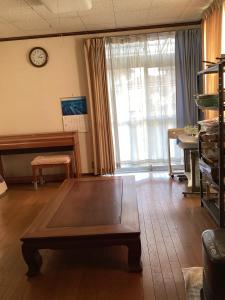 a living room with a table and a clock on the wall at Lemonso - Vacation STAY 19106 in Ichihara +16 photos