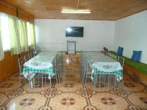 Zimmer mit 2 Tischen und einem TV an der Wand in der Unterkunft Hospedaje Glamour in Machalí