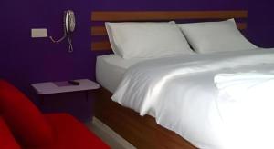 a bedroom with a white bed and a mirror at UII Boutique Place in Sakon Nakhon