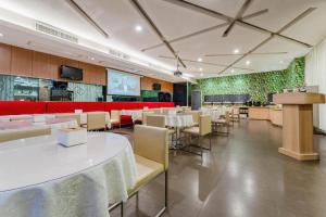 a dining room with tables and chairs in a restaurant at Zhangye Pinmu Hotel(Yuncheng Zhongyin Avenue Store) in Yuncheng