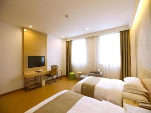 a hotel room with two beds and a flat screen tv at GreenTree Inn Xi'an Terracotta Warriors Huaqing Pool Metro Station in Xi'an