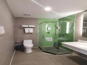 a bathroom with a glass shower and a toilet at GreenTree Inn Xi'an Terracotta Warriors Huaqing Pool Metro Station in Xi'an +155 photos
