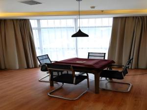 a dining room with a table with chairs and a lamp at GreenTree Inn Yichun Mingyueshan Airport in Yichun
