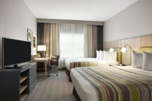 a hotel room with two beds and a flat screen tv at Country Inn & Suites by Radisson, San Antonio Medical Center, TX in San Antonio