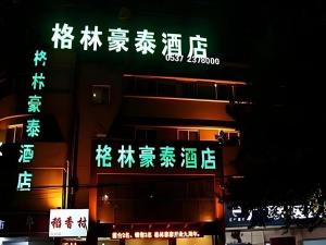 a group of signs with chinese writing on a building at GreenTree Inn Jining Jianshe Road Hotel in Jining